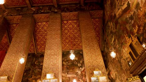 ornate temple interior with murals and buddha statue