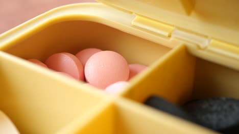 pill organizer with pink and black pills