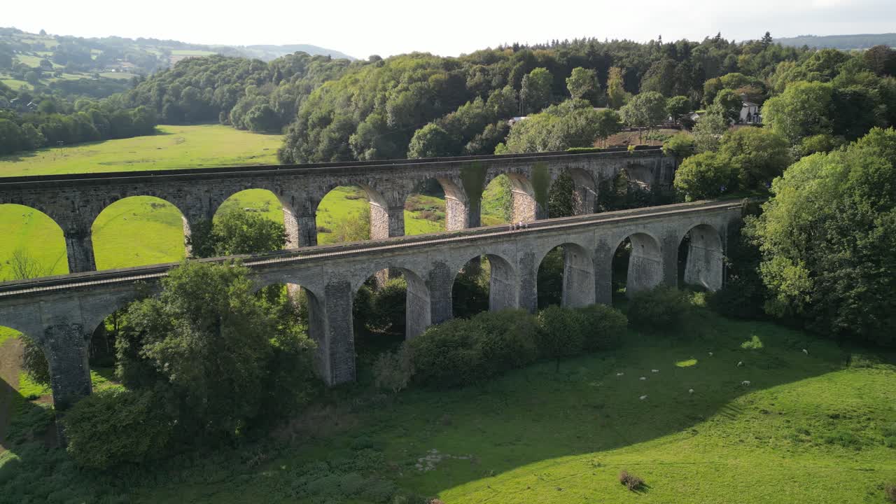 People crossing canal towpath over Chirk Aqueduct, Railway Viaduct in background - aerial drone anti-clockwise rotate and pan - Welsh, English border, Sept 23