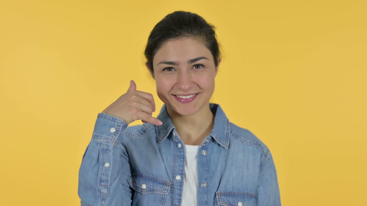 Call me Sign by Young Indian Woman, Yellow Background