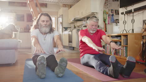 two stiff male pensioners struggle to touch toes during stretching exercise