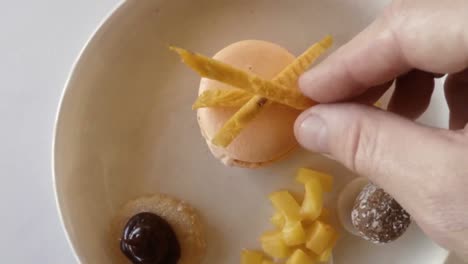 hand of chef garnishing macaroon