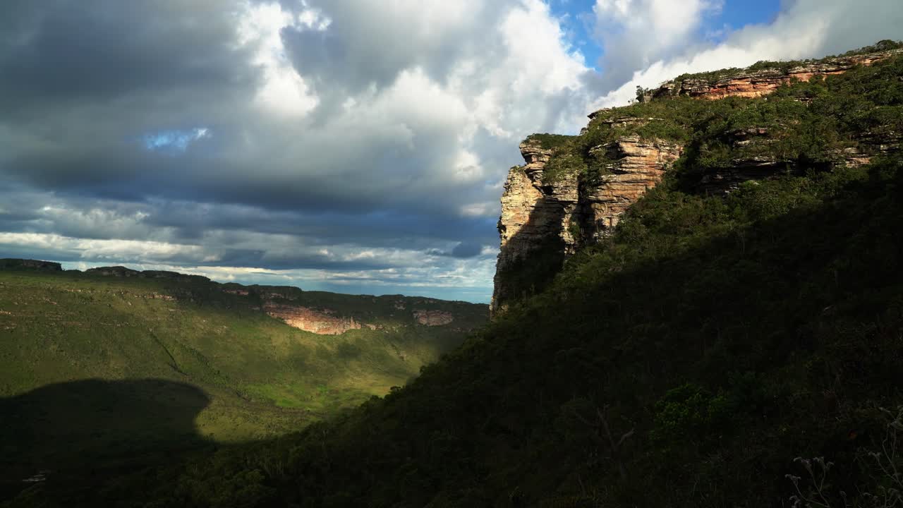 Tilting down shot of a large plateau cliff from the bottom of the Mount of Pai Inácio hike in the Chapada Diamantina national park in northern Brazil on a warm summer evening