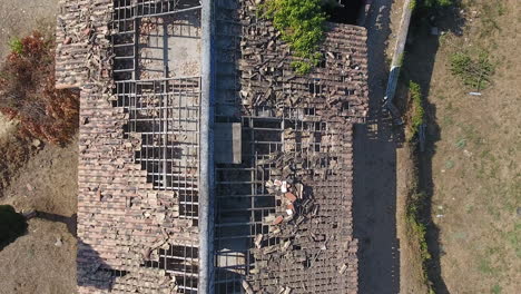 broken tiles on a roof, abandoned house aerial drone view. insurance disaster