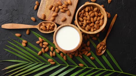 close up of almonds in wooden bowl and almond milk