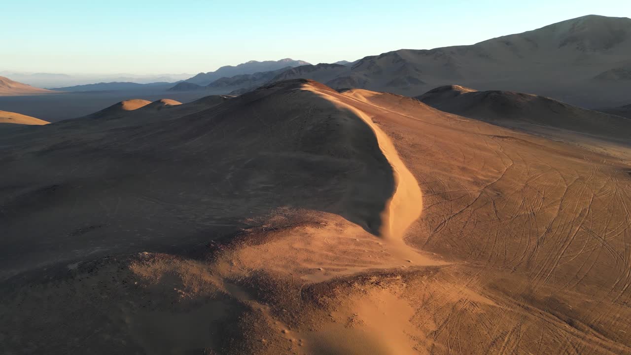 Drone perspective capturing the endless ridges of South America’s highest sand dune at golden hour