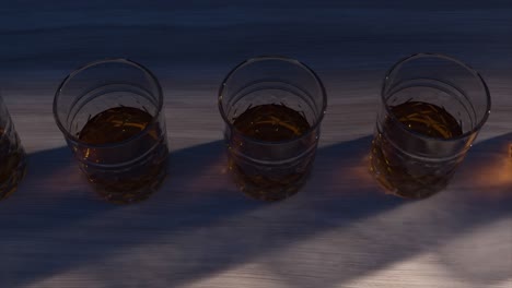 four glasses of alcohol on a wooden table