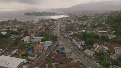 Aerial-footage-of-a-busy-road-in-Freetown,-Sierra-Leone-in-the-morning-mist