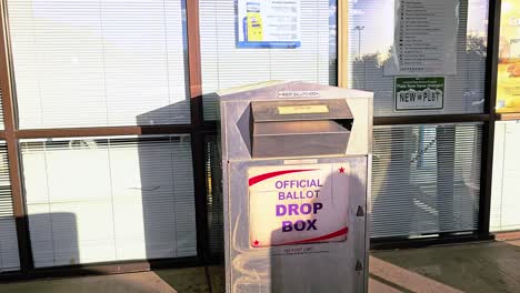 gen x woman votes by dropping mail-in ballot letter in slot at voting booth with offical ballot drop box sign for democratic government election in presidential race