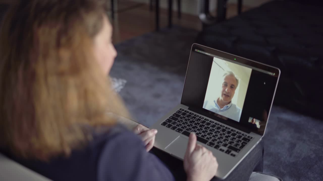 Keski-ikäinen pariskunta käyttämässä kannettavaa tietokonetta ja puhumassa videoyhteyden kautta