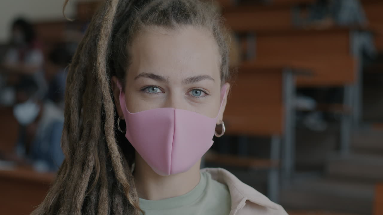 Student in a classroom wearing a pink face mask