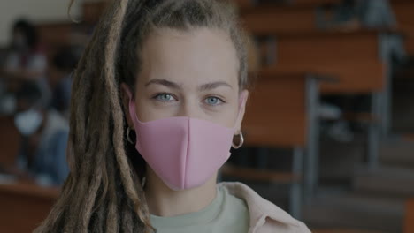 student in a classroom wearing a pink face mask