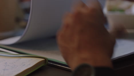 businessman hands browsing corporate documents looking at project proposal in boardroom meeting close up