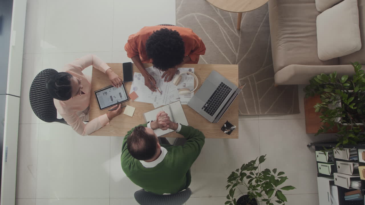 Directly Above of Coworkers Meeting at Office to Discuss Project