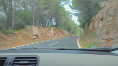 Ein-Blick-Auf-Die-Autobahn,-Die-Zu-Den-Erstaunlichen-Routen-Mit-Dem-Wald-Von-Mallorca,-Spanien,-Führt,-Aufgenommen-Von-Der-Windschutzscheibe-Des-Autos