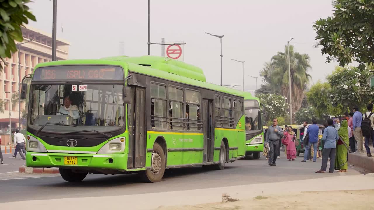 델리 공용 버스가 버스 정류장을 떠나고 있습니다.
