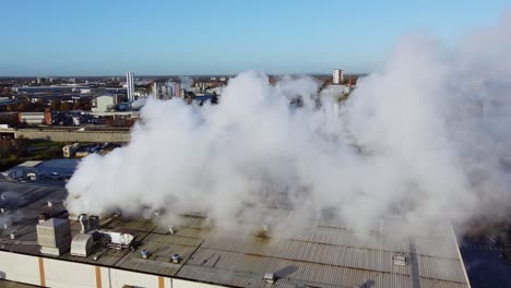 industrial reverse shot of warehouse chimney smoke in manchester