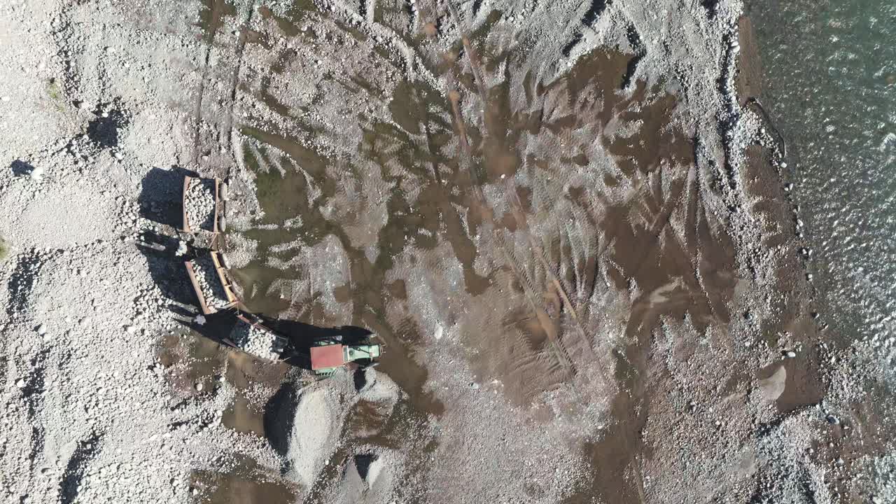Machines working in the riverbed descending from the Andes Mountains