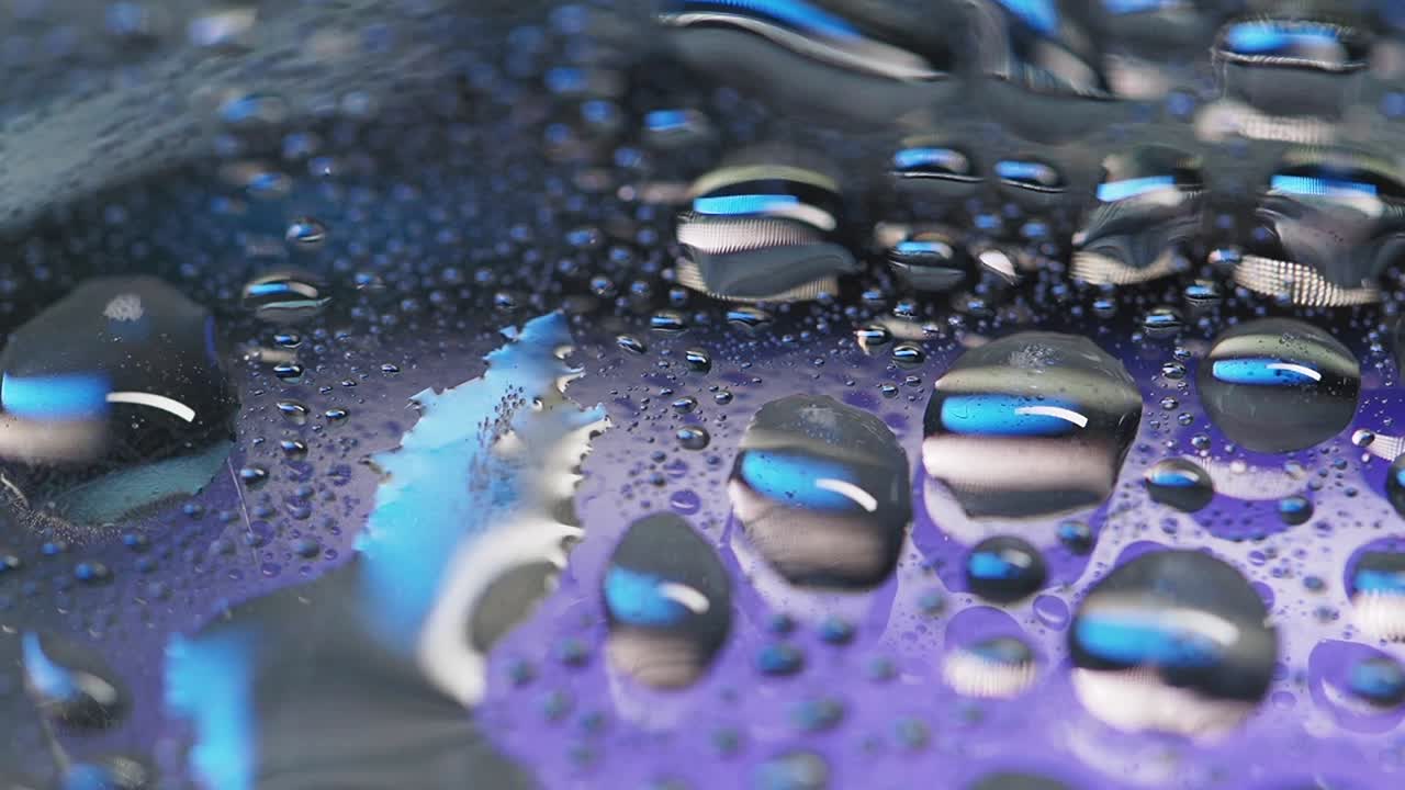 보라색 표면에 물방울이 떨어집니다.