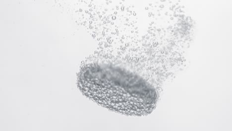 extreme close-up effervescent tablet, pill bubbling underwater. shot on super slow motion camera 1000 fps
