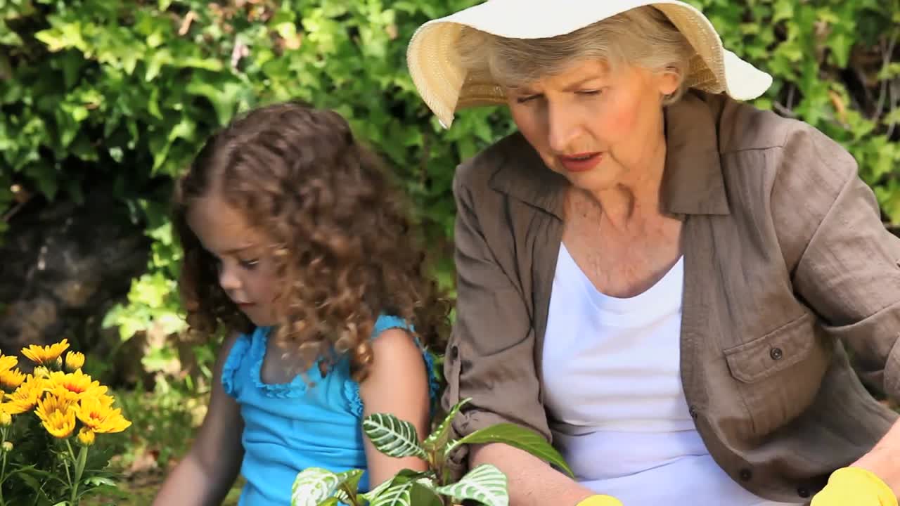 할머니 와 손녀 가 정원 을 가꾸고 있다