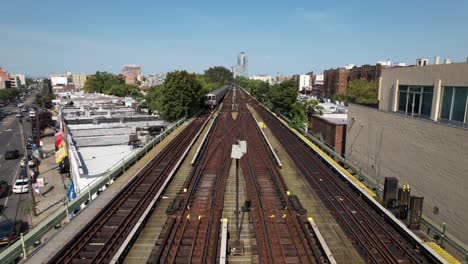 An-aerial-view-of-train-tracks-with-a-train-travelling-towards-the-camera-on-a-sunny-day