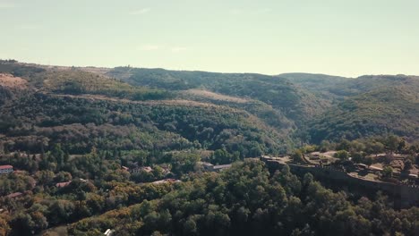 forward drone shot over a hill with an archeological site in bulgaria on a sunny day