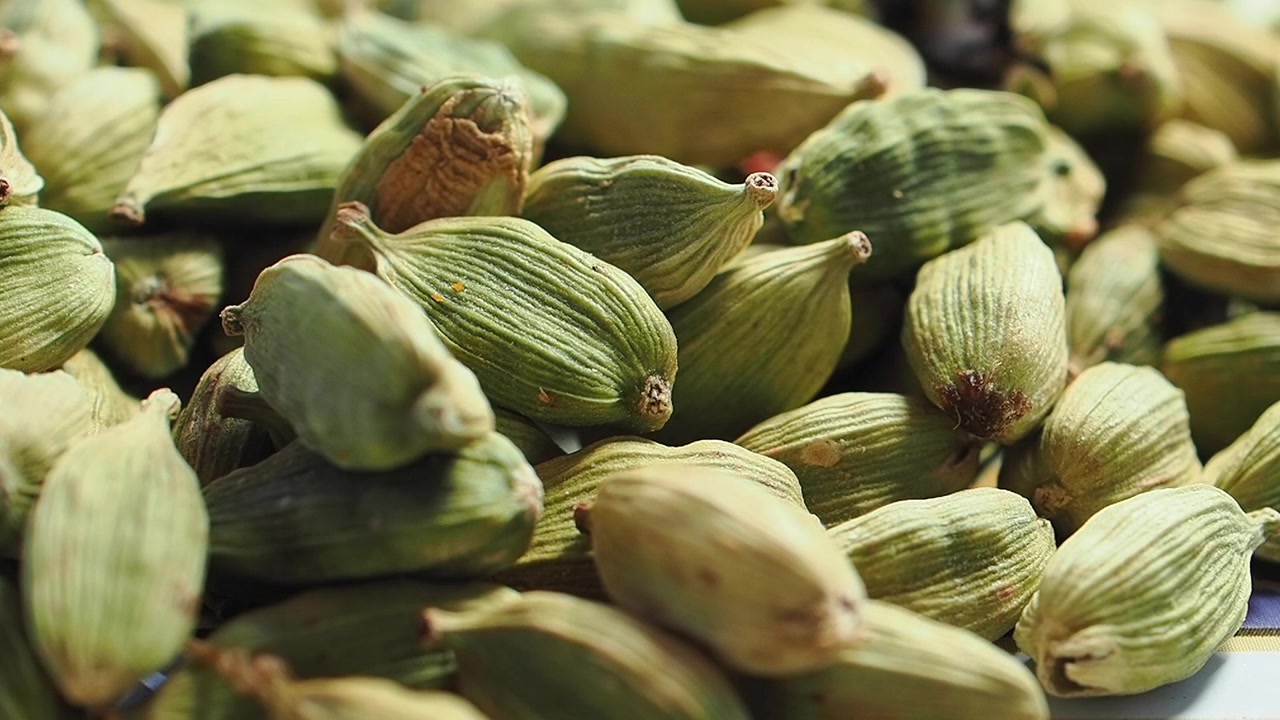Baccelli di cardamomo verde che cadono in un mucchio