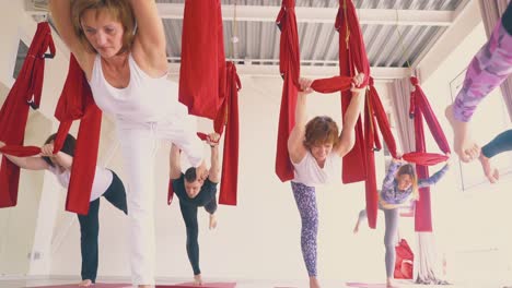 slim young women group enjoys practicing modern fly yoga