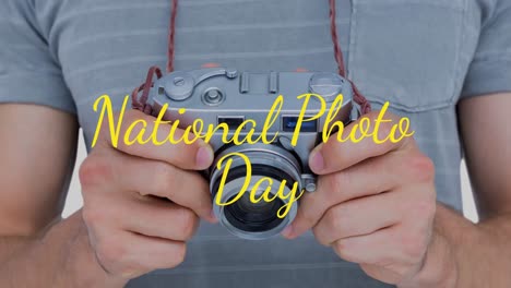 animation of caucasian man holding camera over national photo day text