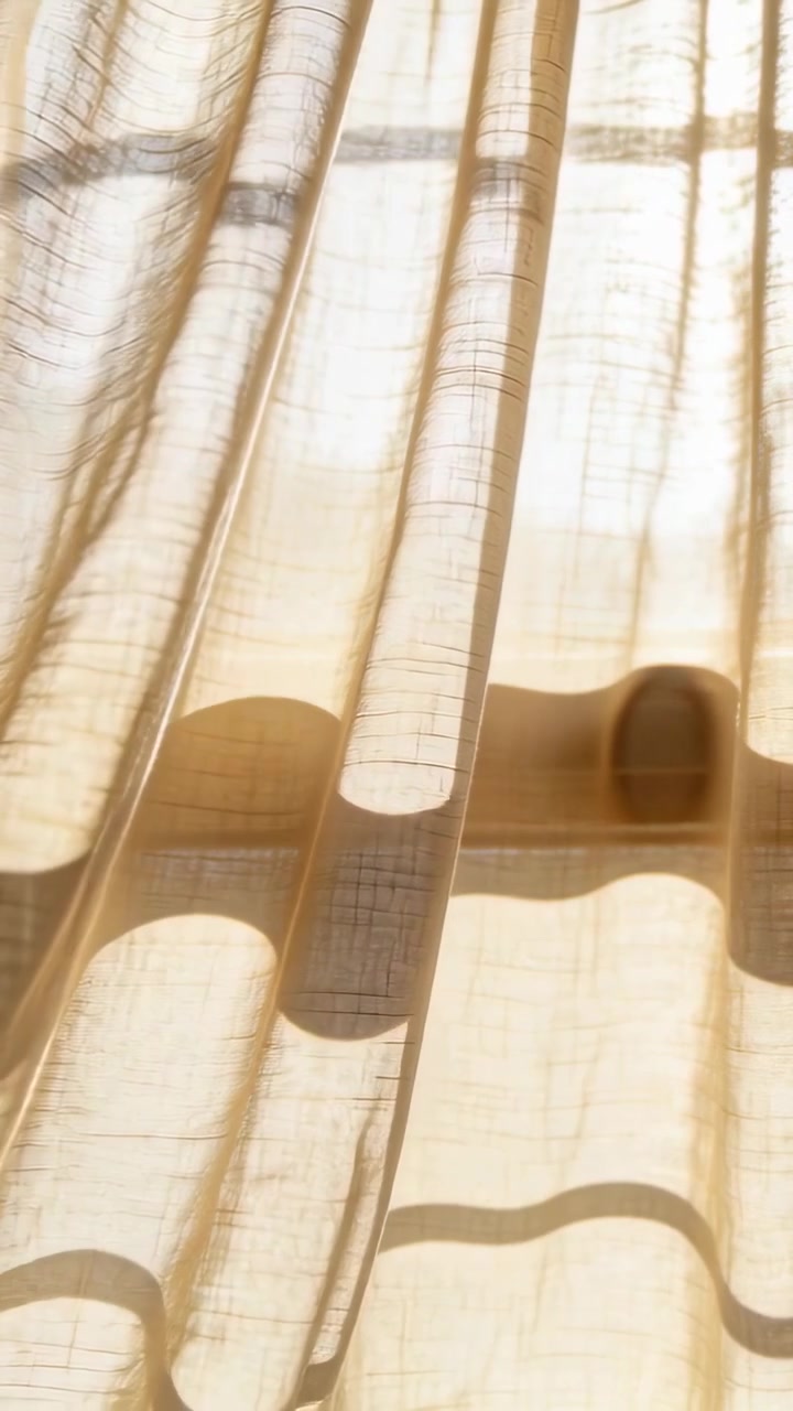 Tenda velata che ondeggia, luce solare che filtra, pieghe che si muovono e proiettano fasce d'ombra per il design