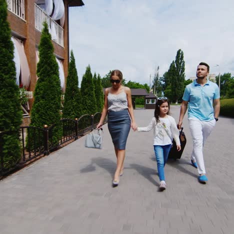 una familia joven con un niño y maletas