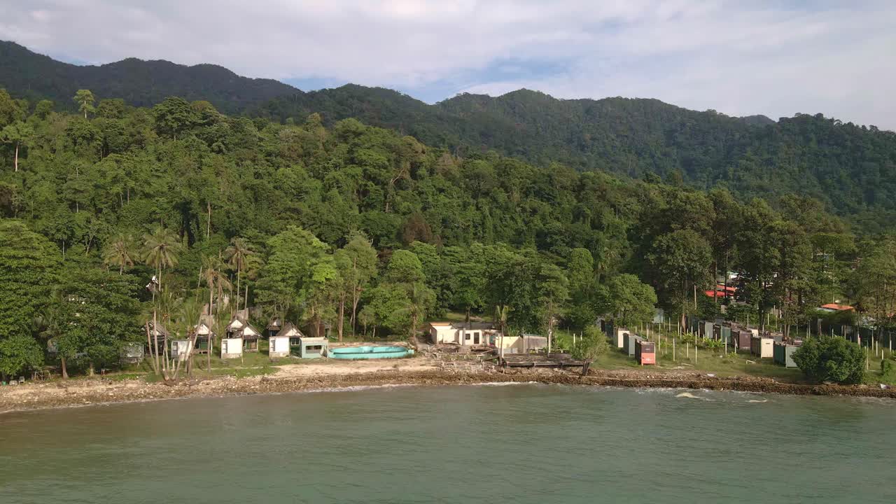 vista aérea de pájaros camión derecho con rotación de un complejo turístico de bungalows de playa abandonado y abandonado en koh chang tailandia debido al efecto de covid en los viajes y el turismo globales