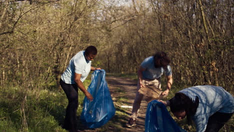 diversos voluntarios recogiendo basura y basura de la zona forestal
