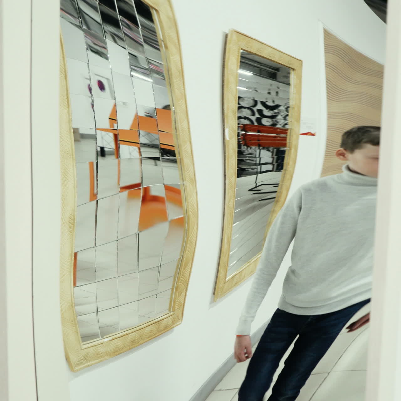 Boy playing with distorted mirror. Museum of entertaining sciences Square video
