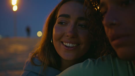 cara de mujer joven cantando una canción en la playa de noche primer plano. adolescente tocando la guitarra
