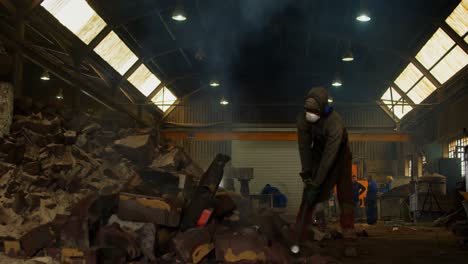 male worker breaking hot mold in foundry workshop 4k