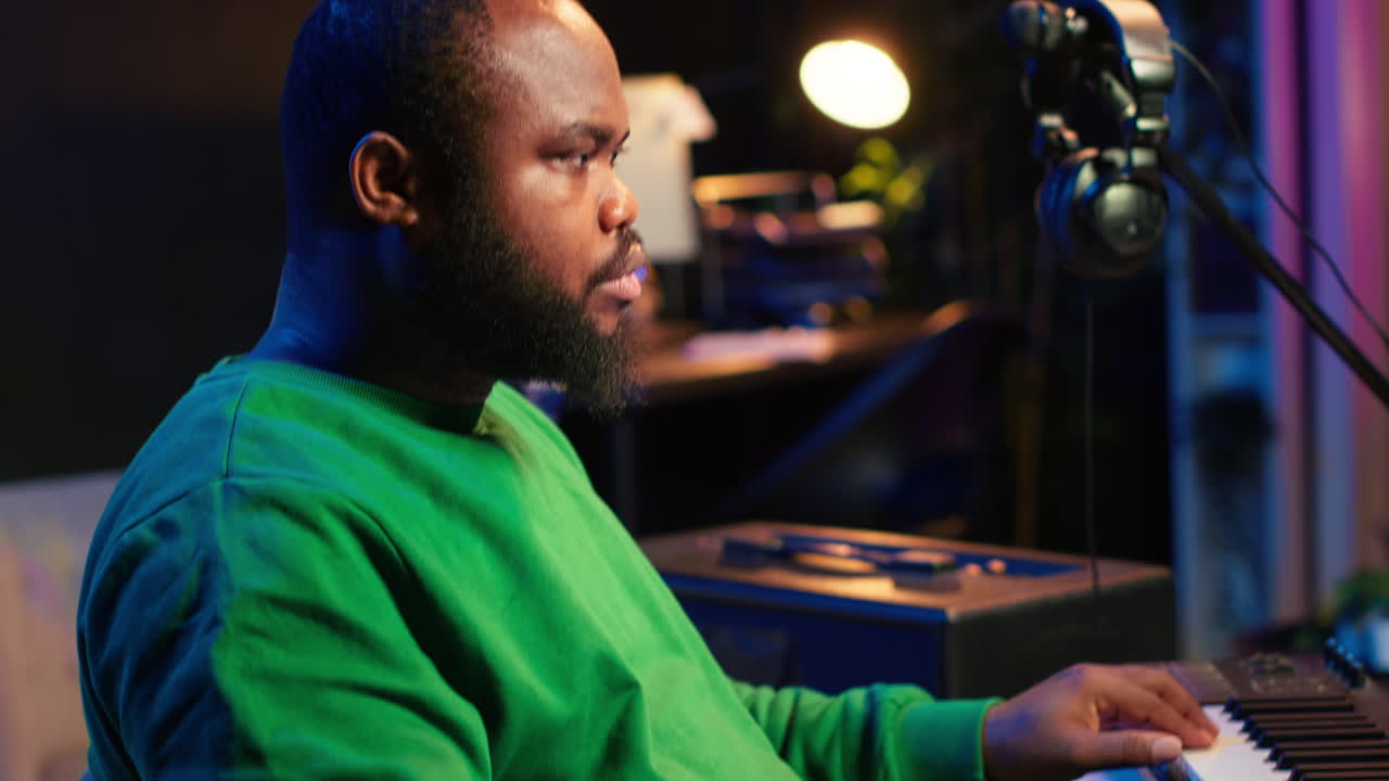 Music composer plays electronic keyboard piano keys and recording new tracks