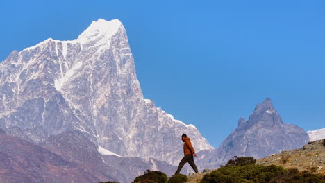aerial view of tourist hiking downhill in dingboche, khumbu region, nepal. mt. cholatse glows backdrop under morning light, capturing scenic himalayan adventure on everest trek, peace and calm travel