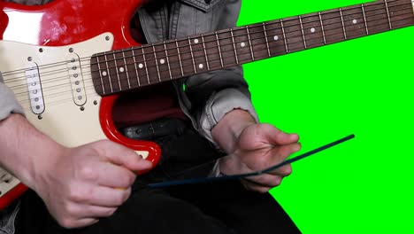 hombre sosteniendo una tableta digital mientras toca la guitarra