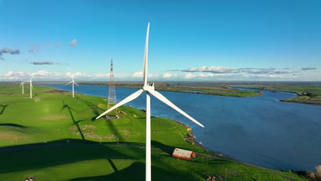 aerial view around wind turbine spinning propeller blades producing clean energy, montezuma hills california