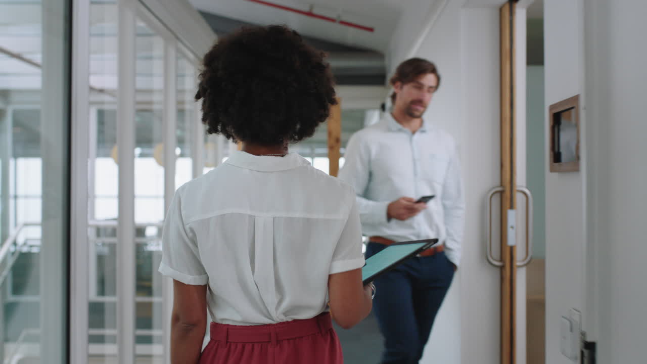 rear view mixed race business woman walking through office holding tablet computer successful career in corporate workplace 4k