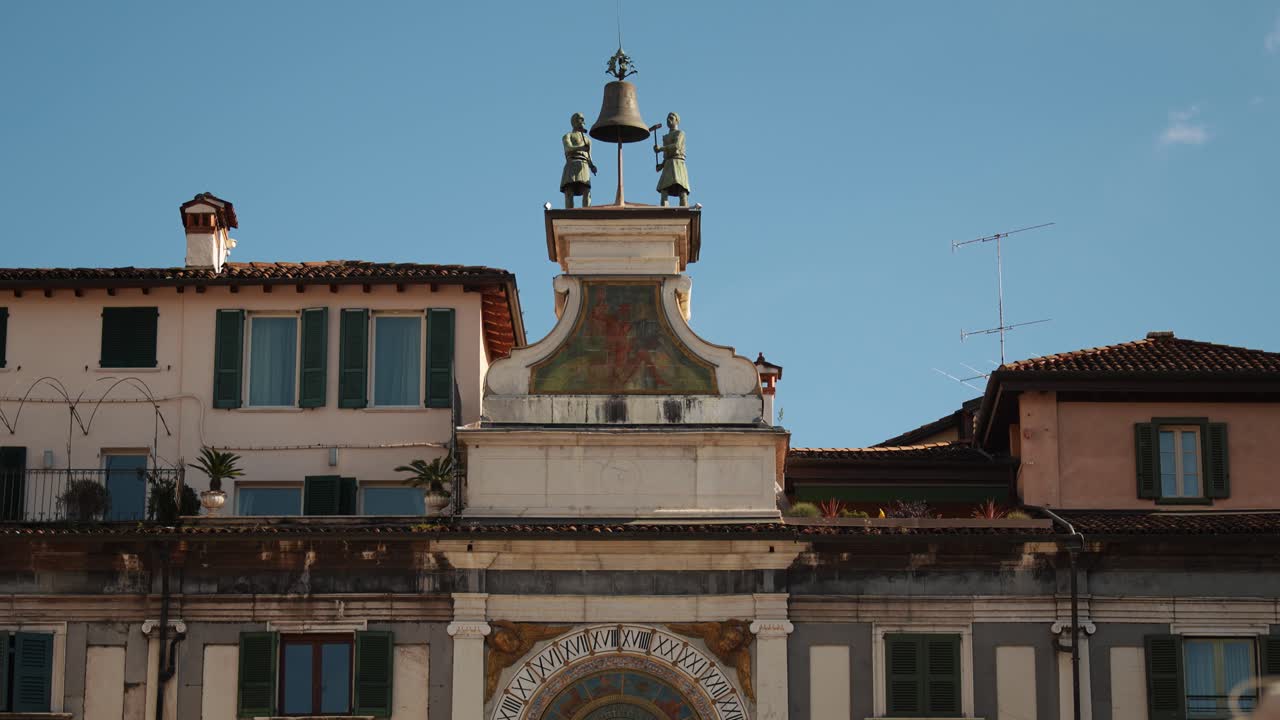 Klokketårnet Torre dell’Orologio på Piazza della Loggia i Brescia, som viser klokken og bronsestatuer