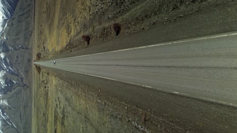 vertical drone shot showing car on avenue road in patagonia during sunny day, argentina