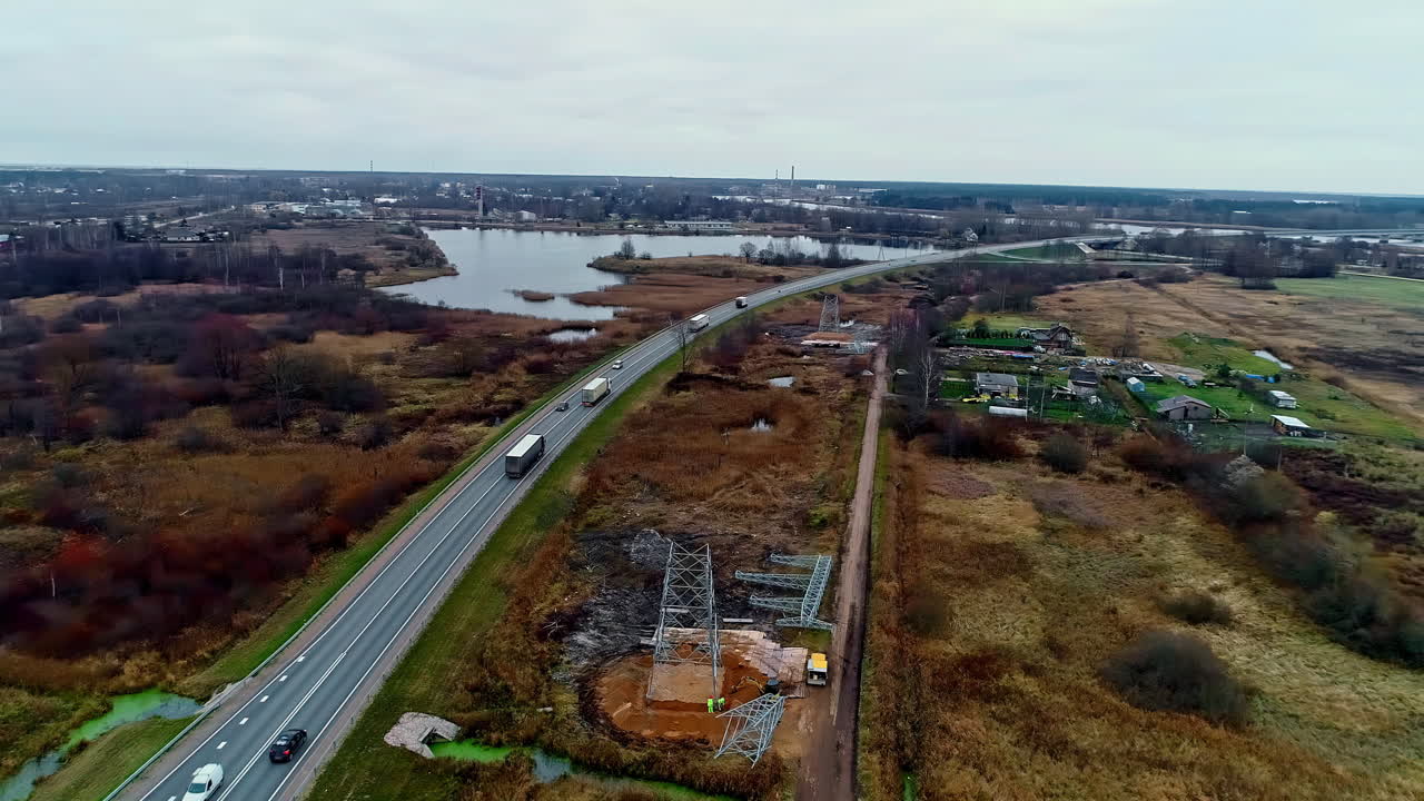 construcción de una torre de transmisión eléctrica junto a una carretera rural - sobrevuelo aéreo