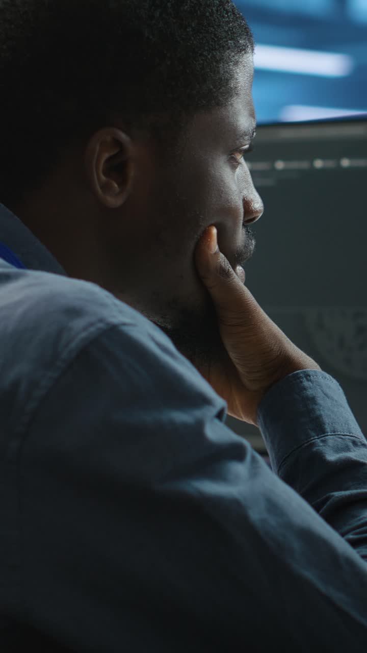 African American Man Coding on Computer in Dark Office