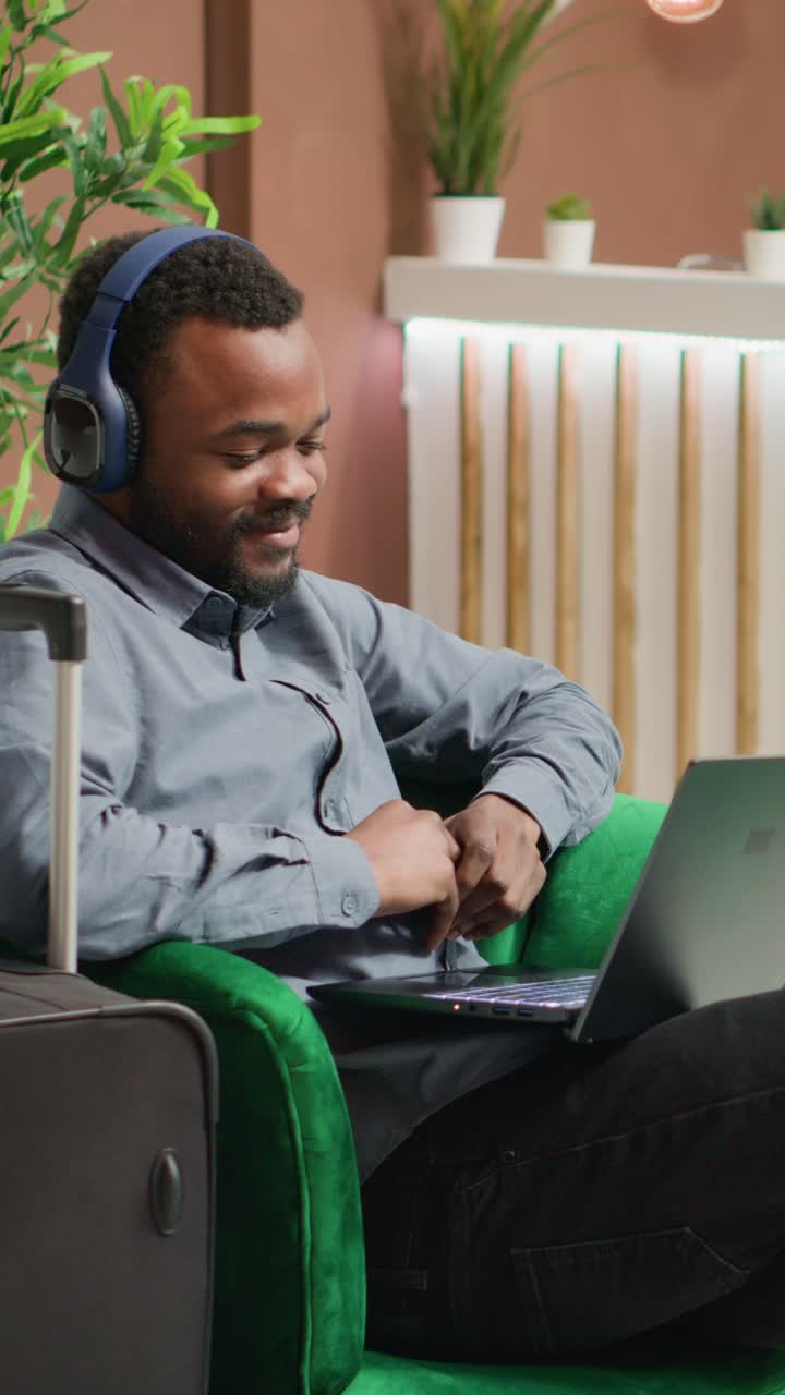 Vertical video Tourist watches tv show in lounge area