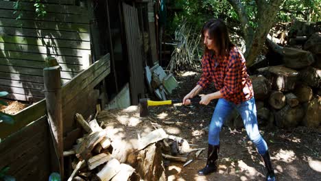 mujer cortando madera con un hacha 4k