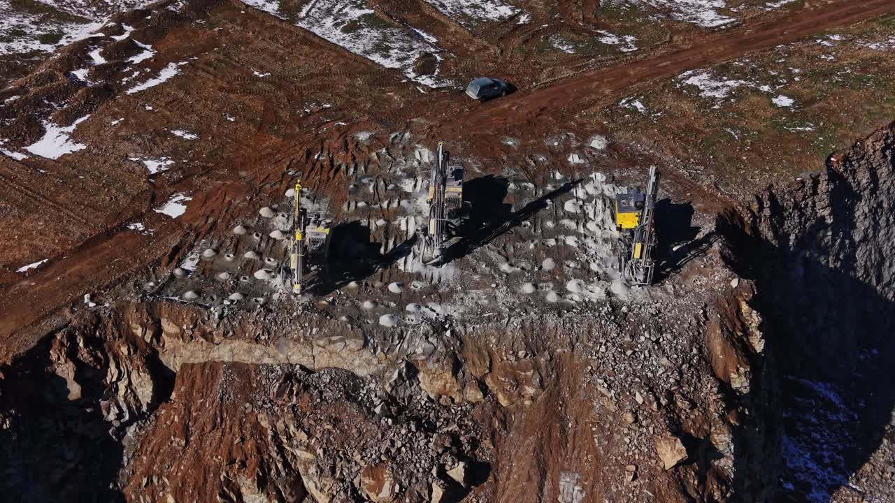 Construction equipment on rocky terrain at a mining site in winter