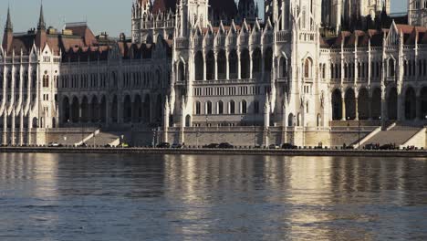 budapest city center view with parliament building and danube river on a sunny day, gothic architecture, cars moving on the street, medium low angle distant shot